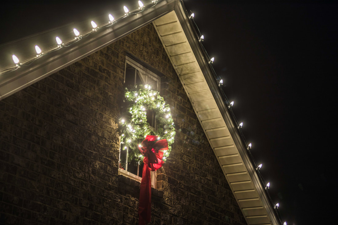 Lit Christmas wreath on a house
